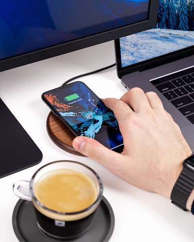 mobile phone charging iPhone in front of turned on monitor cell phone